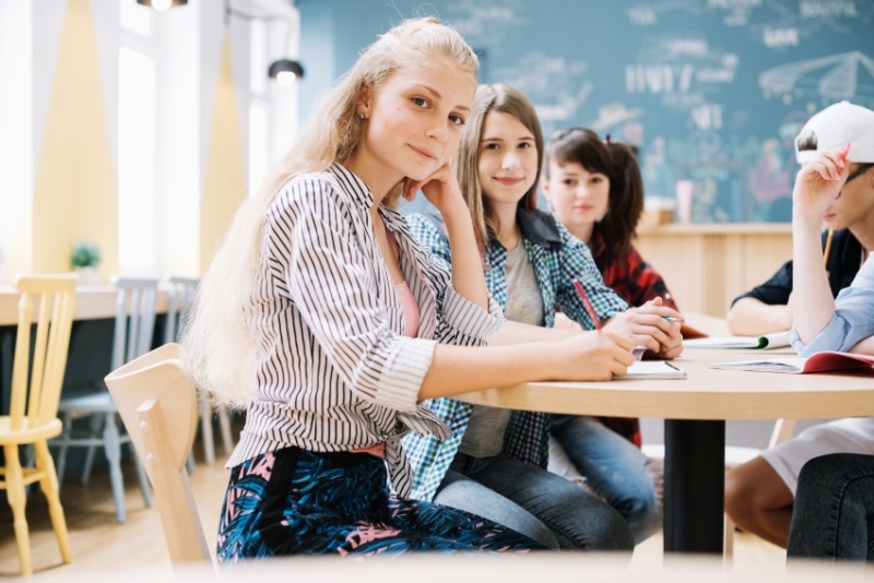 Students in classroom smiling.